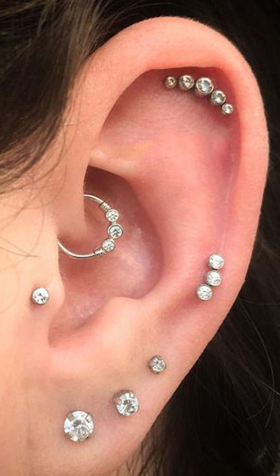 shiny ear accessorizing with tiny studs and a studded hoop earring in the daith will highlight your style
