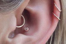 stylish ear accessorizing with tiny gold studs and hoops including a daith piercing with a gold hoop