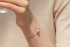 05 a minimalist chain bracelet with a single and large gold bead and tiny beads on its ends is very cute
