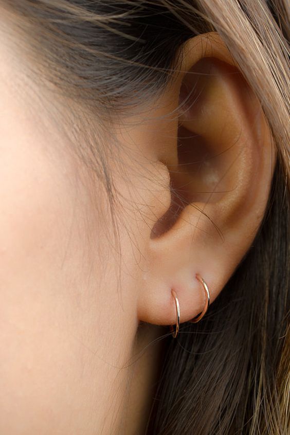 a duo of tiny gold hoops are a nice and stylish minimalist idea to accessorize your ears
