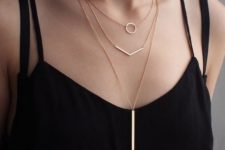 11 geometric layering necklaces with a circle, a geometric line and a long wide bar hanging down