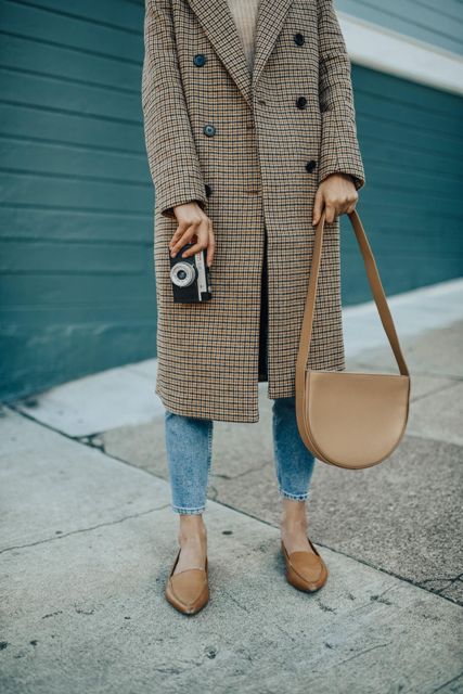 With gray sweater, cropped jeans, brown flats and leather bag