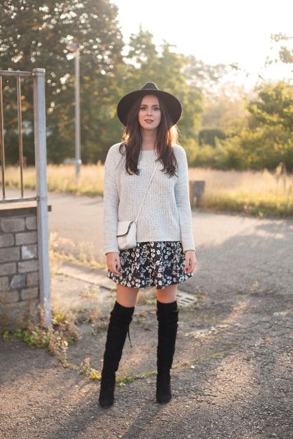 With gray sweater, floral skirt, white bag and black over the knee boots