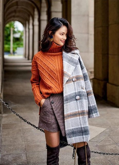 With orange turtleneck sweater, printed wrapped mini skirt and over the knee boots