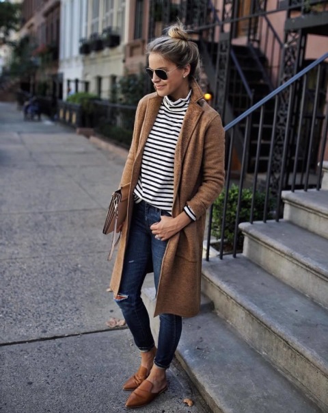 With striped shirt, brown coat, distressed jeans and clutch
