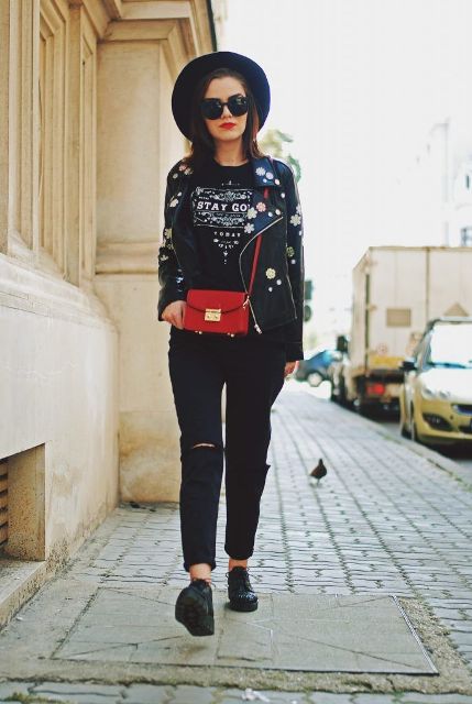 With wide brim hat, labeled t-shirt, red bag, distressed pants and flat shoes
