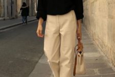 a black jumper, neutral oversized cropped pants, white trendy shoes and a neutral bag to go to work