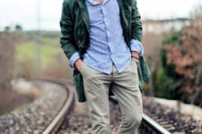 a blue printed shirt, grey pants, grey and neone yellow trainers, a green parka for a bright fall look