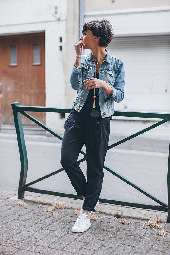 a comfy outfit with a black top, black oversized pants, white sneakers and a bleached denim jacket