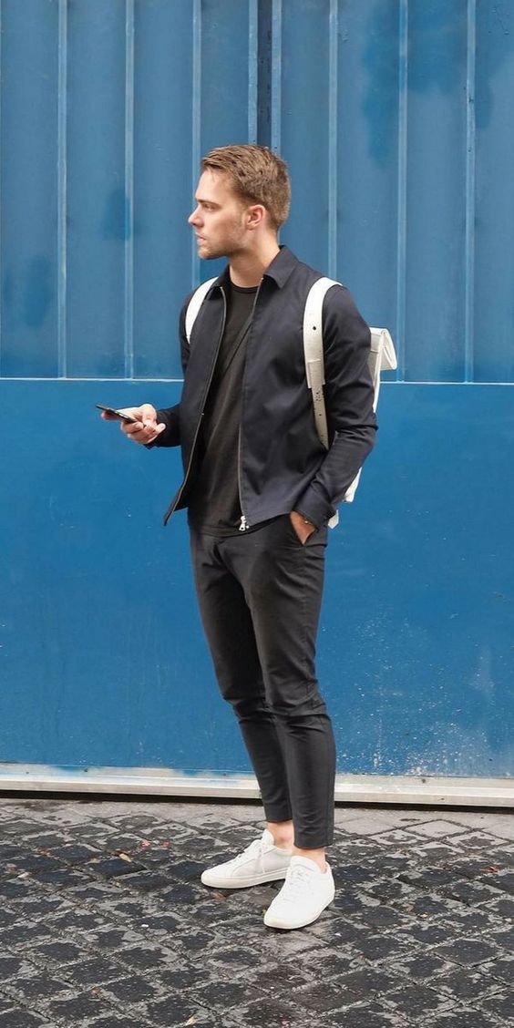 a minimalist fall look with a black tree, black pants, a navy shirt with a zip, white sneakers and a backpack