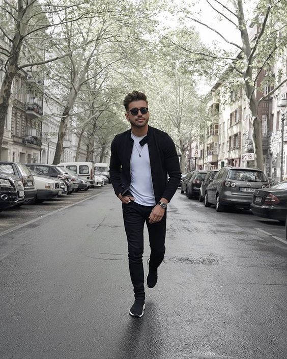a monochromatic fall look with a white tee, black jeans, a black leather jacket and black trainers