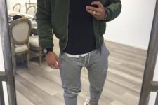 a white tee, a blakc jumper, a green bomber jacket, grey joggers and grey trainers for a sport chic look
