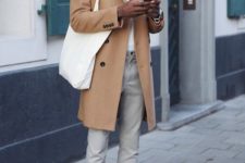 a white turtleneck, grey pants, a camel trench, white sneakers and socks, a cap and a tote