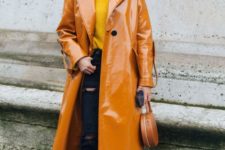an amber lacquere straight leather trench, black ripped jeans, a mustard turtleneck and white boots