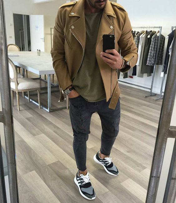 grey joggers, an olive green t-shirt, a camel moto jacket, grey and black trainers for a comfy sporty look