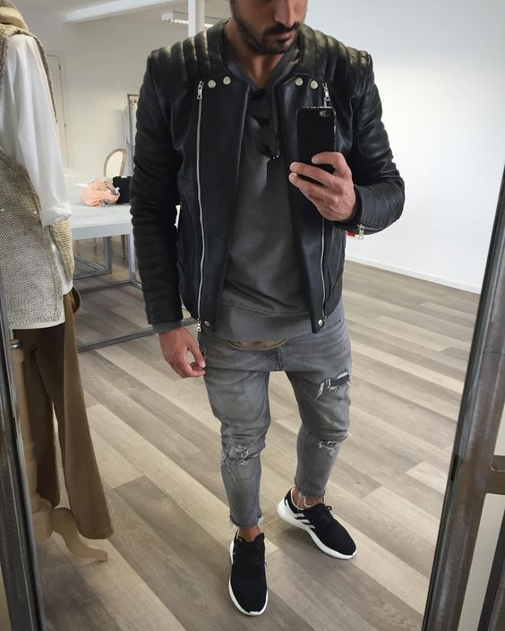 grey ripped jeans, a grey tee, a black leather jacket, black trainers for a chic monochromatic look