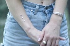three microdermal piercings on the arm is a cool and shiny idea for a modern girl