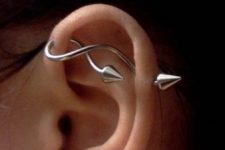 two lobe piercings and a single horizontal industrial one done with a curvy and wavy arrow
