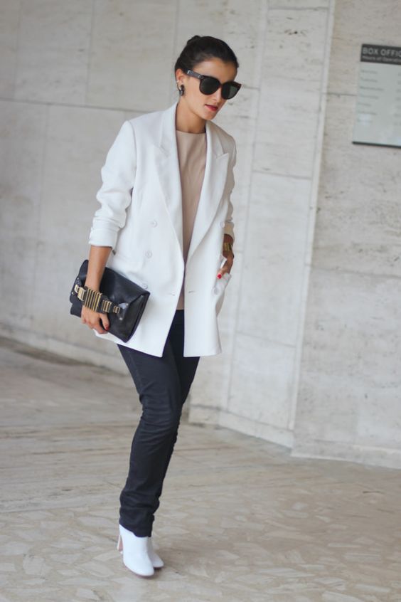 a neutral top, black straight jeans, white boots, a white oversized blazer and a black bag