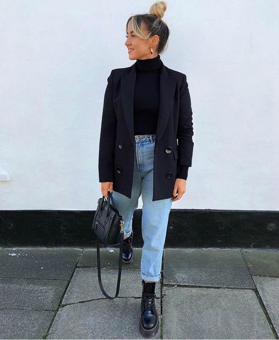 a trendy outfit with a black turtleneck, an oversized black blazer, blue jeans, black boots and a bag