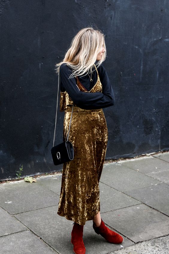a chic party look with a black turtleneck, a gold velvet midi slip dress, red boots and a black bag