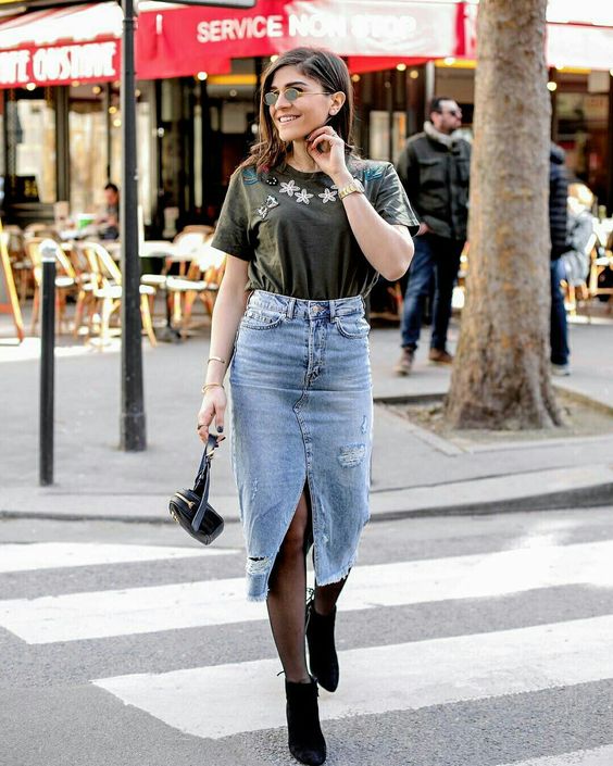 a rock inspired look with an embroidered tee, a blue denim midi with a slit, black booties and a black bag