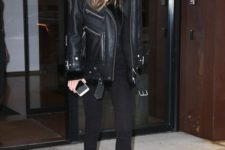 10 Gigi Hadid wearing a black top and leggings, black boots and a black aviator coat