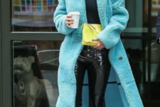 Rosie Huntington-Whiteley wearing black lacquer pants, a black turtleneck, white boots and a turquoise midi faux fur coat