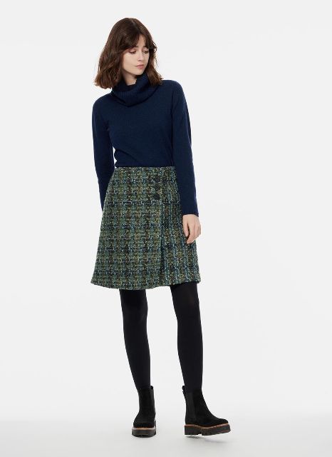 With navy blue turtleneck, black tights and black flat boots