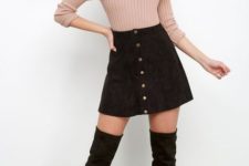 With pastel colored sweater and black over the knee boots