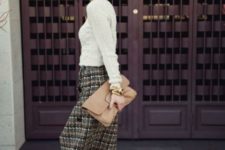 With white sweater, beige leather clutch and black high heels