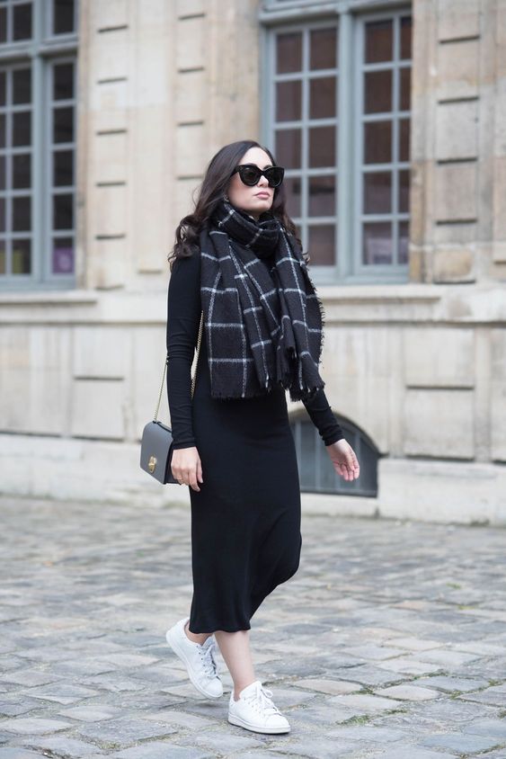 a black knit midi dress with long sleeves, white sneakers, a black and white scarf and a black bag