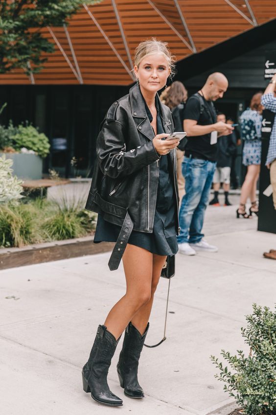 a black mini shirtdress, an oversized black moto jacket and black cowboy boots for the fall
