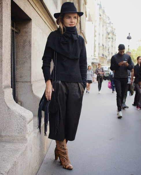 a gorgeous total black look with a sweater, a scarf, leather culottes, a bag, a hat and printed boots