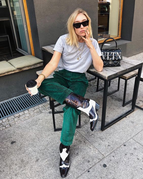 a grey tee, emerald velvet pants and black and white cowboy boots for a bold touch