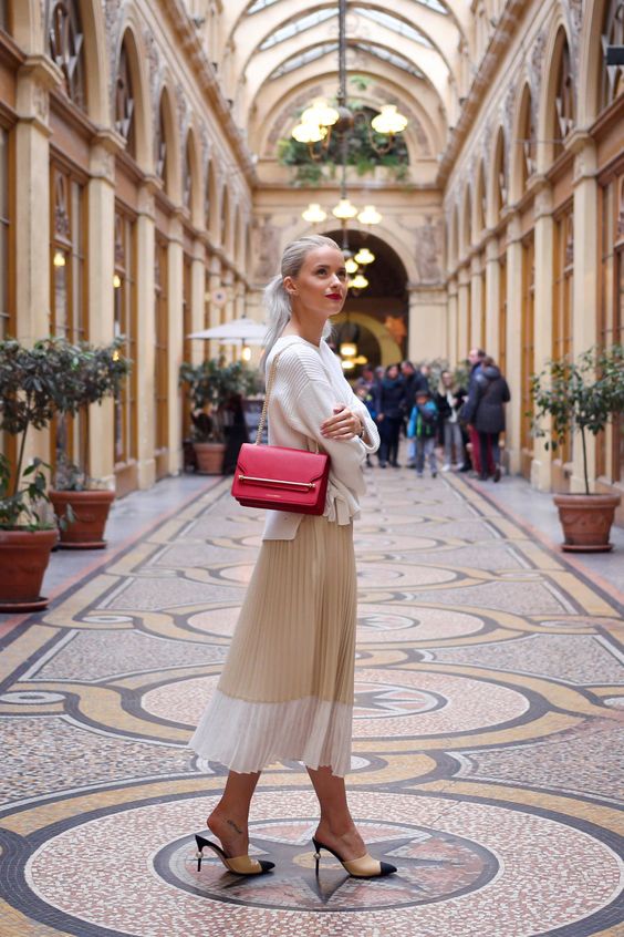 a romantic look with a white jumper, a color block tan and white midi, mules and a red box bag