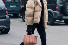 a sporty look with black leggings, a black hoodie, black sneakers and a tan puffer jacket plus an amber bag