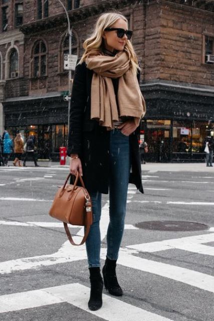 a simple look with blue cropped skinnies, black sock boots, a black coat and a brown bag