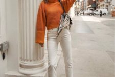 13 a vintage-inspired look with an orange cropped sweater, white straight jeans, two tone shoes and a bag
