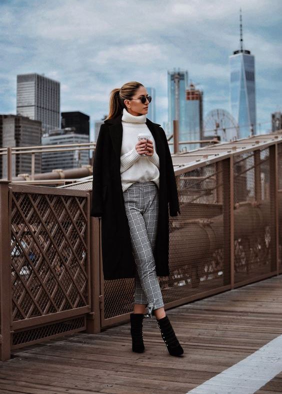 a stylish yet simple look with a white sweater, grey plaid pants, black booties with buttons and a coat
