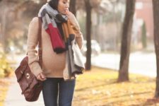 With beige sweater, skinny jeans, red high boots, brown leather bag and white pom pom hat