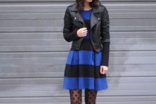 With blue and black striped dress, black hat, black leather jacket and lace up boots