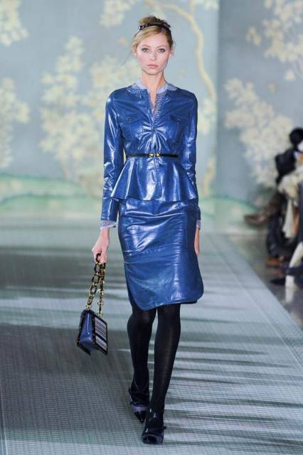 With blue patent leather skirt, black shoes and chain strap bag