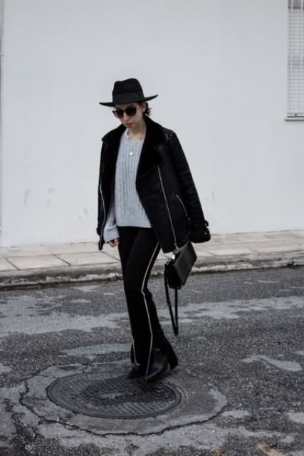With gray sweater, black jacket, wide brim hat, black bag and boots