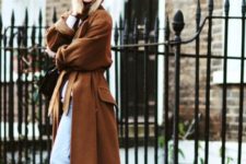 With light blue cuffed jeans, brown maxi coat and black boots