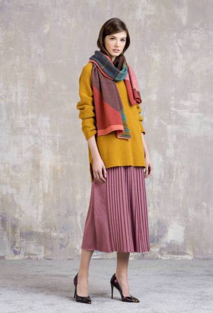 With mustard yellow long sweater, pink pleated midi skirt and pumps