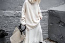 With oversized sweater, tote bag and black low heeled boots