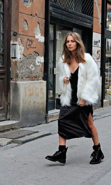 a black slip dress, a white fur coat, black combat boots and socks for an extravagant monochromatic look