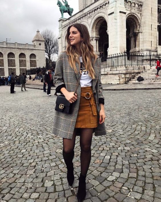 a printed tee, a rust suede mini skirt with a ring sash, a plaid coat, black booties and a blakc crossbody
