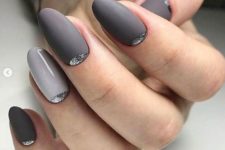 a shiny and matte manicure done in several shades of grey and with silver glitter touches just wows